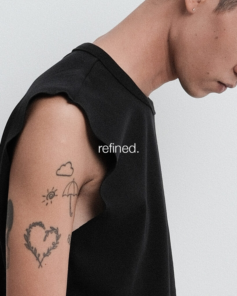 Raw-cut armhole of the black Tank Relaxed